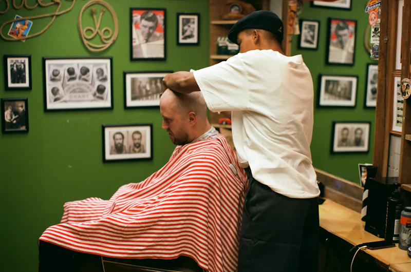 A barber giving a customer a haircut in a small barbershop